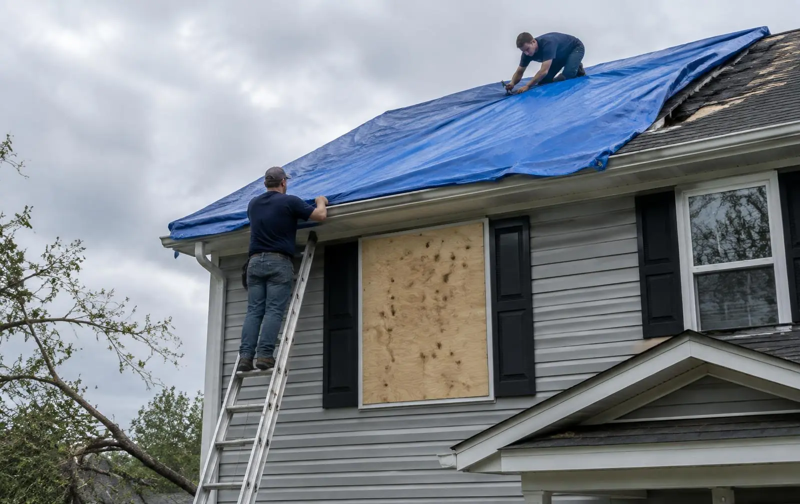 Crew tarping a storm-damaged roof and boarding up a window in Orange County, NY
